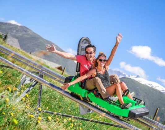 Un couple faisant de la luge l'été à l'Alpe d'Huez